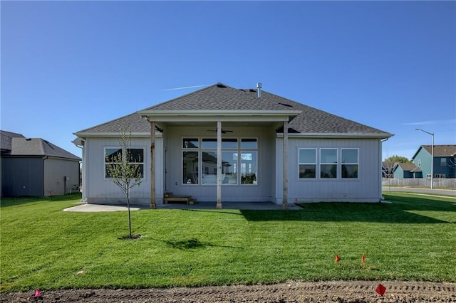 rear view of house featuring a yard and ceiling fan