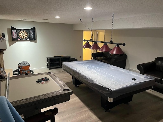 recreation room featuring billiards, a textured ceiling, and light wood-type flooring