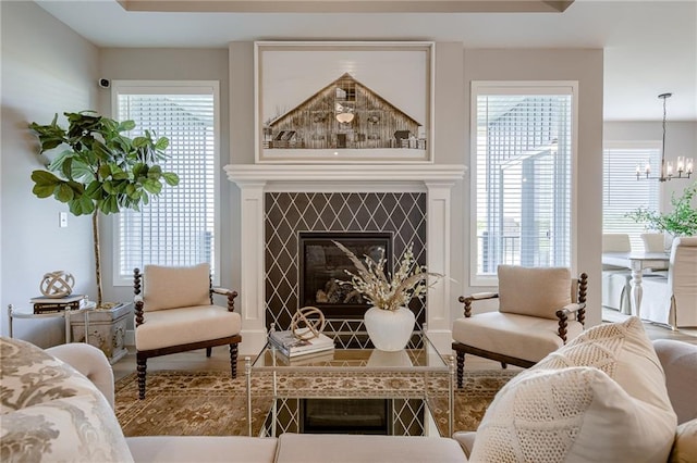 living area with a notable chandelier and a tiled fireplace