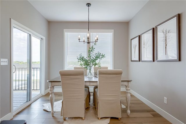 dining space featuring an inviting chandelier, hardwood / wood-style floors, and a healthy amount of sunlight