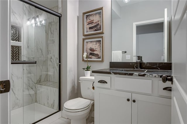 bathroom featuring a shower with shower door, vanity, and toilet