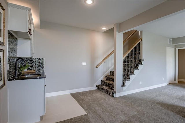 staircase with carpet floors and sink