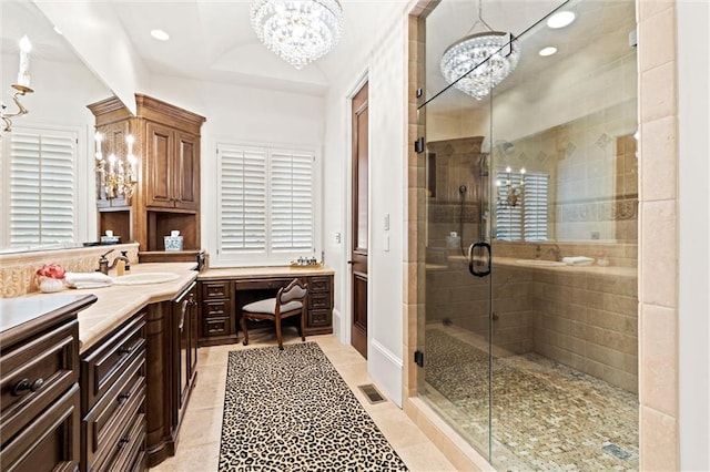 bathroom with tile patterned flooring, vanity, a chandelier, and a shower with shower door