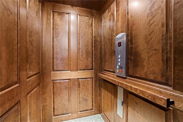 details featuring elevator and wooden walls