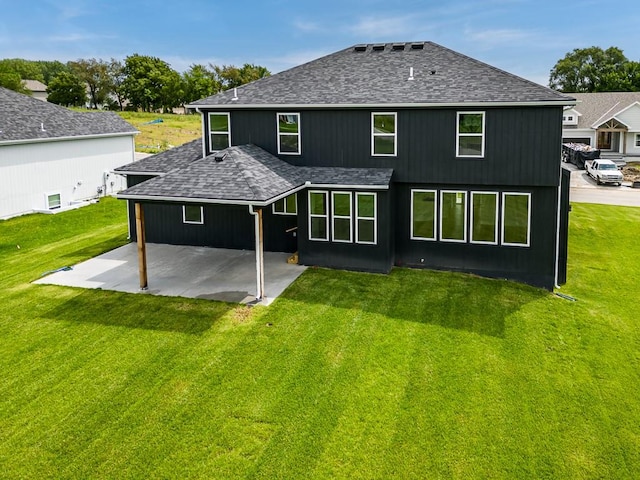 rear view of house with a yard and a patio