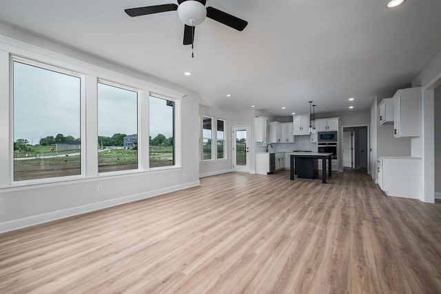 unfurnished living room with light hardwood / wood-style floors and ceiling fan