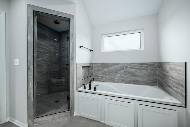 bathroom with tile flooring and independent shower and bath