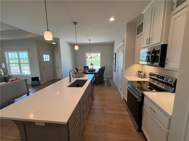 kitchen featuring pendant lighting, white cabinets, dark wood-type flooring, black / electric stove, and sink