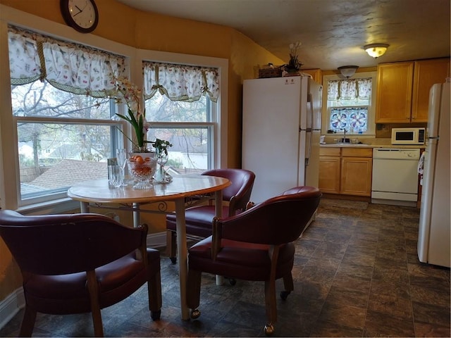 dining space featuring dark tile floors and sink