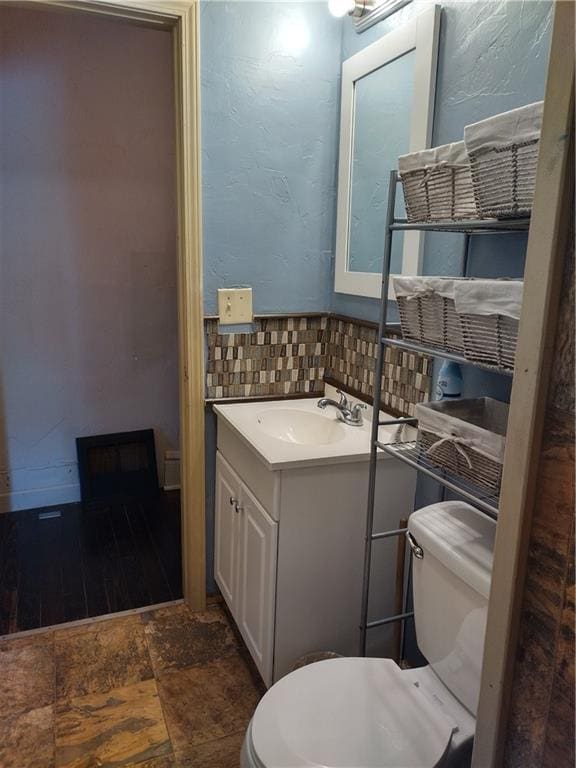 bathroom with backsplash, large vanity, toilet, and tile flooring