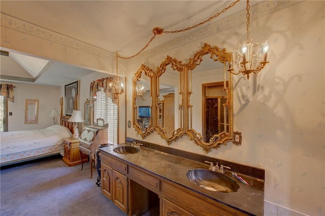 bathroom featuring dual bowl vanity and an inviting chandelier