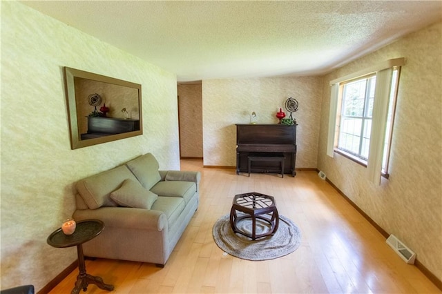 living room featuring light hardwood / wood-style flooring and a textured ceiling