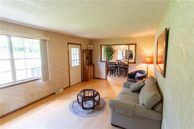 living room with a textured ceiling and light hardwood / wood-style floors