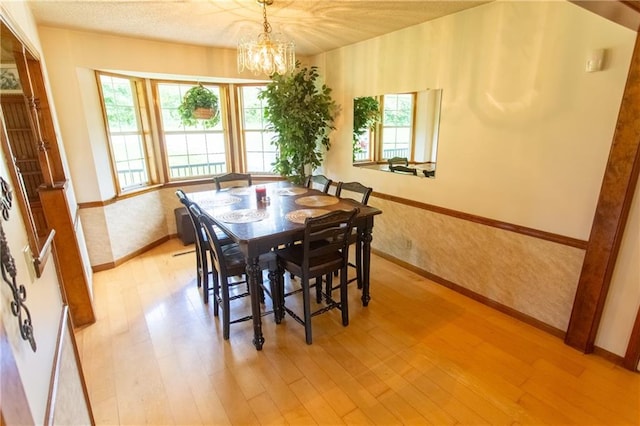 dining area with a notable chandelier and light hardwood / wood-style flooring