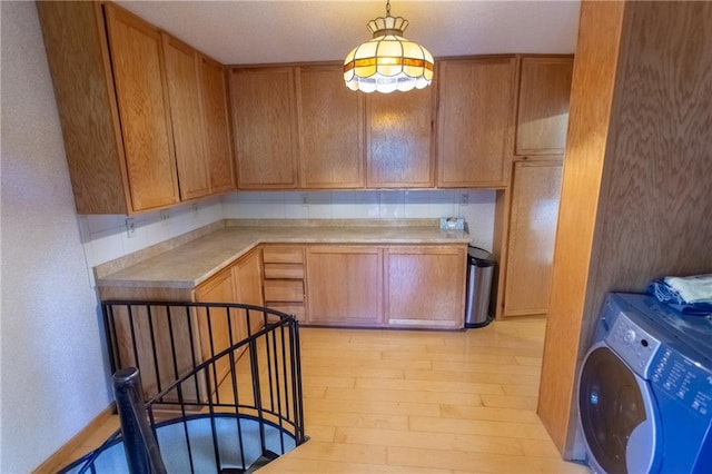 kitchen featuring decorative light fixtures and light hardwood / wood-style flooring