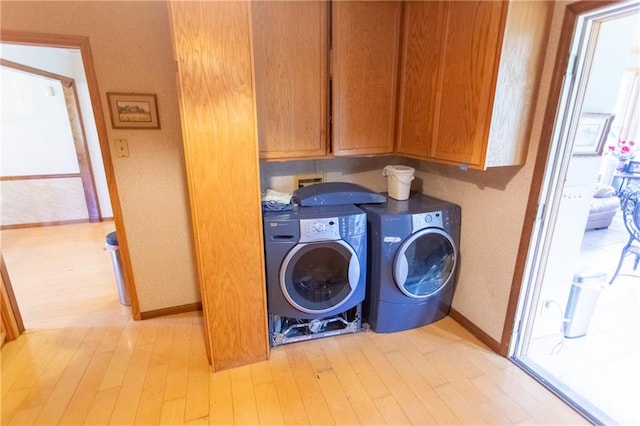 laundry room with cabinets, light wood-type flooring, washer hookup, and washer and dryer