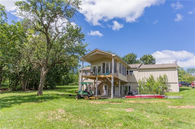 rear view of property with a balcony and a lawn