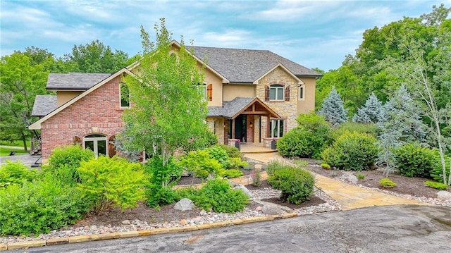 29800 E 65th St, Blue Springs, MO 64014 - view of front of house featuring stone siding, a porch, stucco siding, and a shingled roof