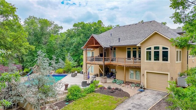 29800 E 65th St, Blue Springs, MO 64014 - back of house with stucco siding, a garage, cooling unit, a patio area, and asphalt driveway