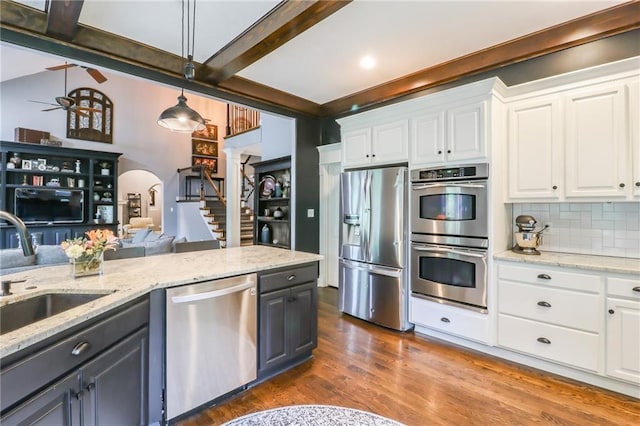 29800 E 65th St, Blue Springs, MO 64014 - kitchen featuring stainless steel appliances, a sink, beam ceiling, white cabinetry, and dark wood finished floors