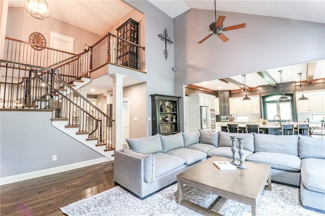 29800 E 65th St, Blue Springs, MO 64014 - living room featuring wood finished floors, ornate columns, ceiling fan, stairway, and high vaulted ceiling