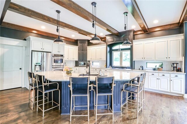29800 E 65th St, Blue Springs, MO 64014 - kitchen with appliances with stainless steel finishes, white cabinetry, a large island with sink, beam ceiling, and recessed lighting