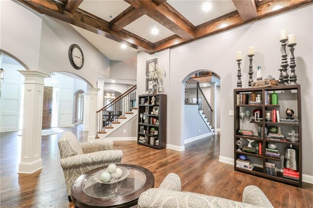 29800 E 65th St, Blue Springs, MO 64014 - living room featuring arched walkways, ornate columns, stairway, coffered ceiling, and beamed ceiling