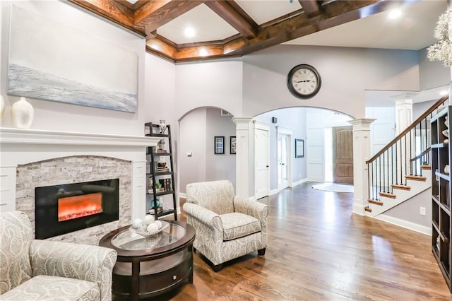 29800 E 65th St, Blue Springs, MO 64014 - living area featuring arched walkways, wood finished floors, a towering ceiling, ornate columns, and baseboards