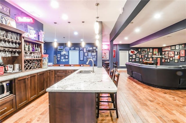 29800 E 65th St, Blue Springs, MO 64014 - indoor bar featuring light wood-style floors, decorative light fixtures, stainless steel microwave, and recessed lighting
