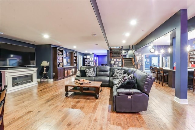 29800 E 65th St, Blue Springs, MO 64014 - living area with stairs, hardwood / wood-style flooring, a bar, recessed lighting, and a glass covered fireplace