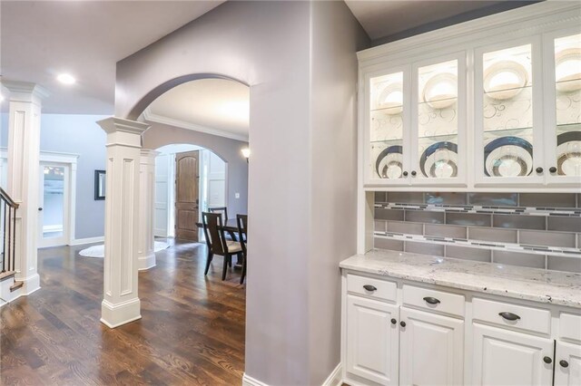 29800 E 65th St, Blue Springs, MO 64014 - bar with arched walkways, ornate columns, backsplash, dark wood finished floors, and crown molding