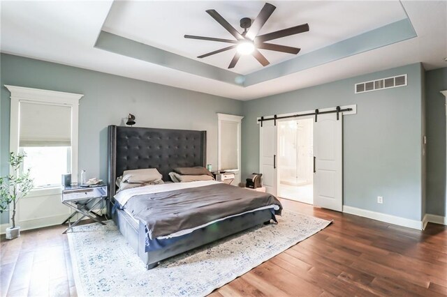 29800 E 65th St, Blue Springs, MO 64014 - bedroom with a barn door, a raised ceiling, baseboards, and wood finished floors