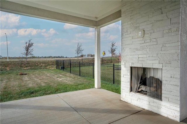 view of patio featuring an outdoor stone fireplace and a rural view