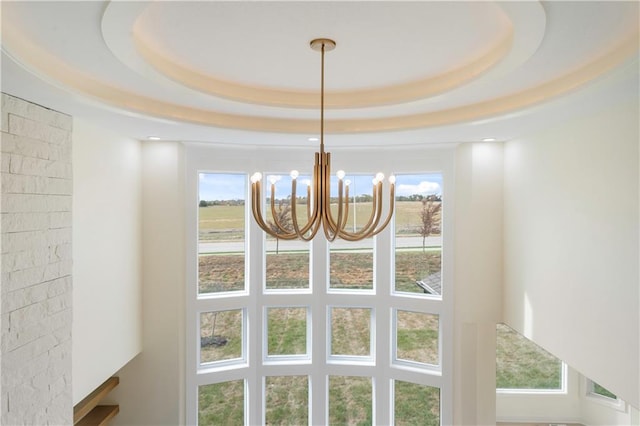 interior details with a notable chandelier and a raised ceiling