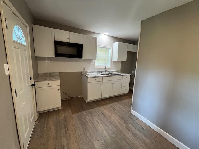 kitchen with dark hardwood / wood-style floors, white cabinets, and sink