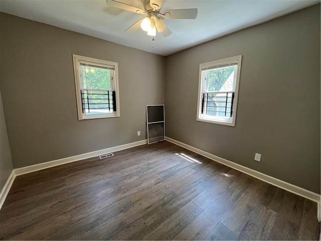 empty room with ceiling fan and dark wood-type flooring