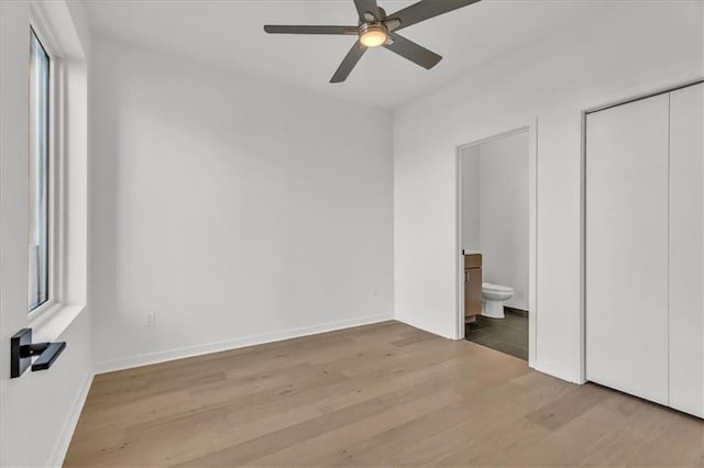 unfurnished bedroom featuring light wood-type flooring, ceiling fan, and connected bathroom