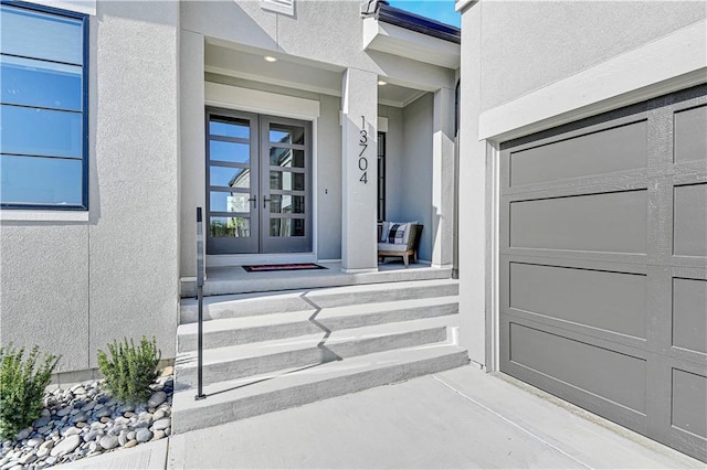13704 Pembroke Ln, Leawood, KS 66224 - property entrance with stucco siding, french doors, and a garage