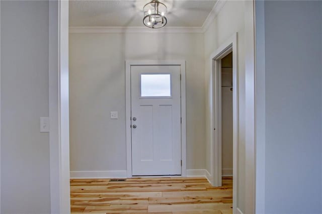 entrance foyer featuring crown molding and light wood-type flooring