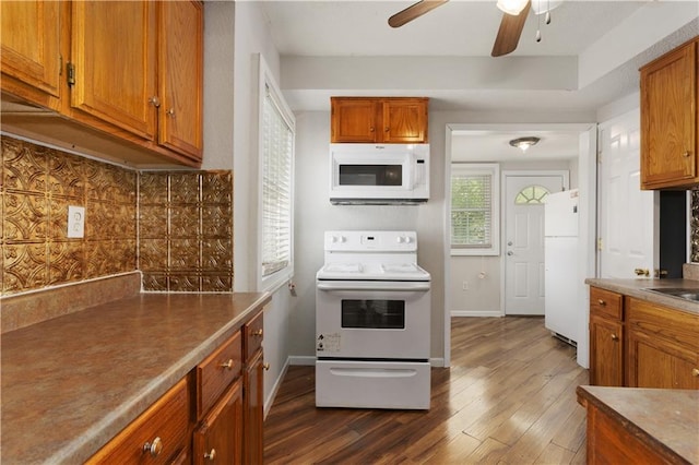 kitchen featuring dark wood-type flooring, ceiling fan, white appliances, and tasteful backsplash