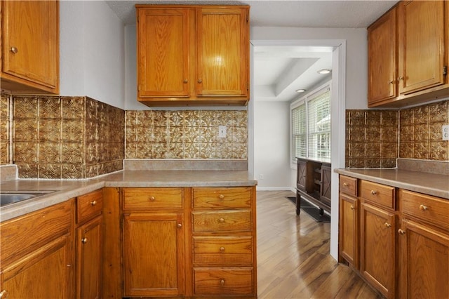 kitchen with light hardwood / wood-style flooring and tasteful backsplash