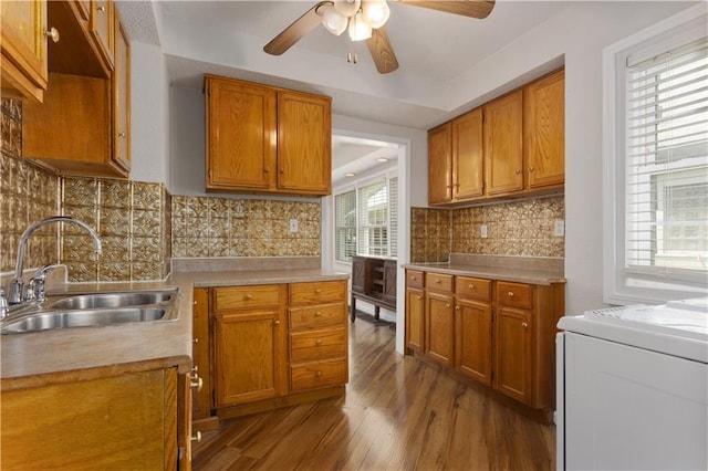 kitchen with sink, ceiling fan, light hardwood / wood-style flooring, backsplash, and washer / clothes dryer