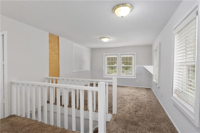 interior space featuring a textured ceiling and light carpet