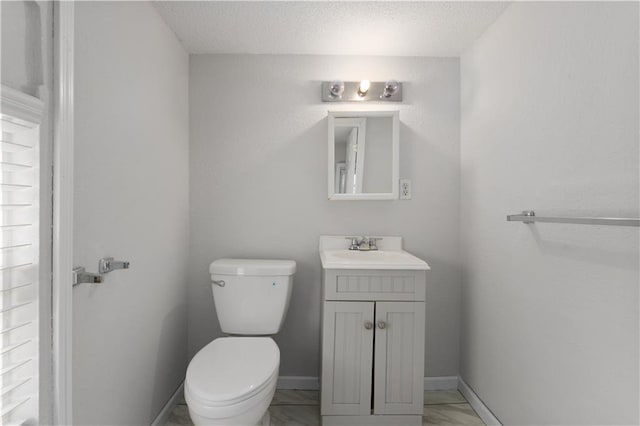 bathroom with vanity, a textured ceiling, tile floors, and toilet