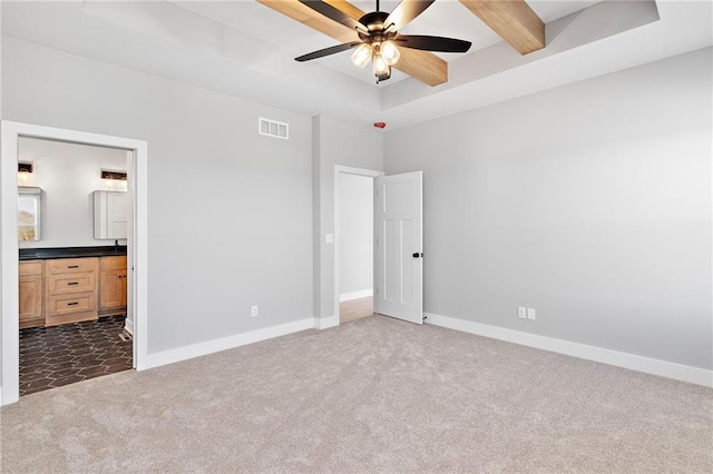 unfurnished bedroom with connected bathroom, beamed ceiling, ceiling fan, and dark colored carpet