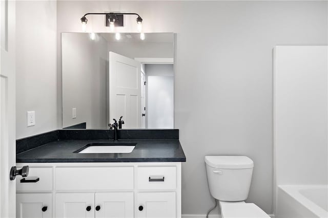 bathroom with vanity, a washtub, and toilet