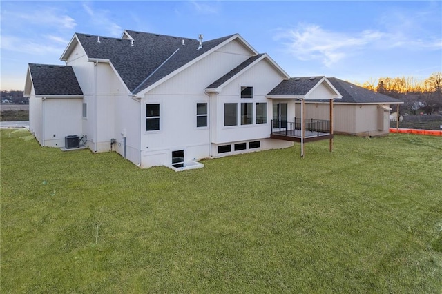 rear view of house with cooling unit and a yard