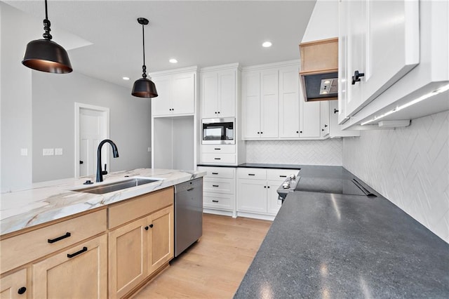 kitchen with light brown cabinetry, sink, decorative light fixtures, and white cabinets