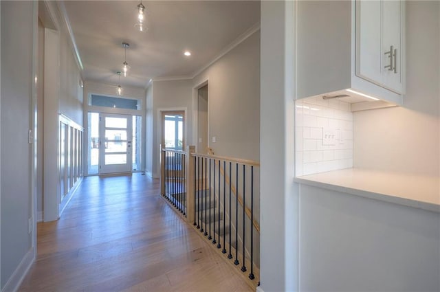 hallway with ornamental molding and light wood-type flooring