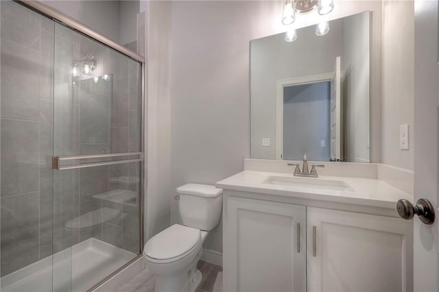 bathroom with vanity, a shower with shower door, and toilet